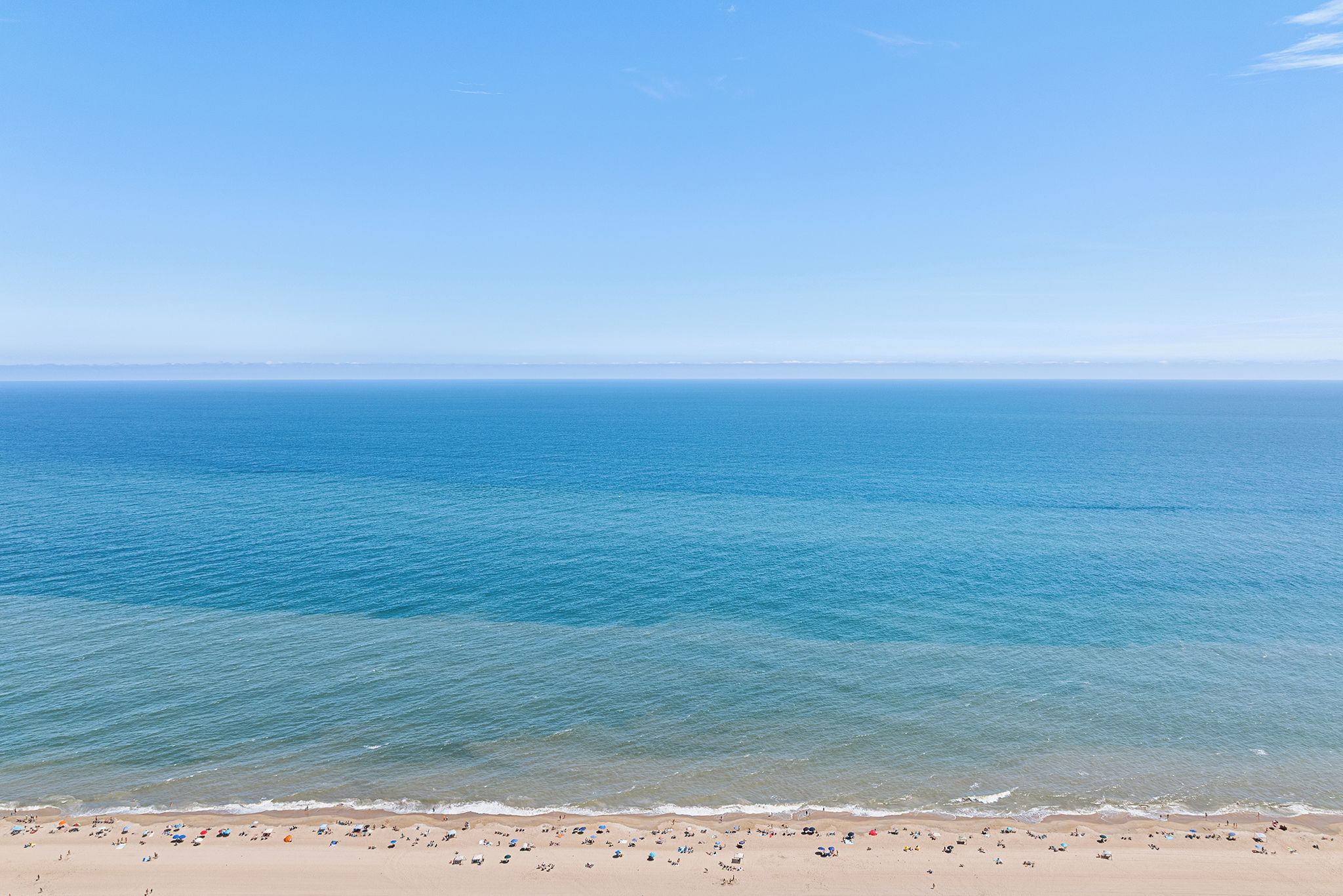 Ein Strand mit klarem, blauen Wasser und einem Sandstrand.
