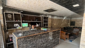 A modern kitchen with a marble island, built-in appliances, and a unique ceiling design. - The Classic Residency Hotel & Banquet  (Shimla)