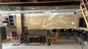 A room with a wooden bench, a sofa, and several chairs. - The Classic Residency Hotel & Banquet  (Shimla)