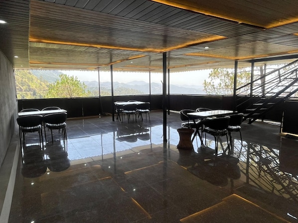 A modern conference room with a glass wall, black chairs, and a polished floor.