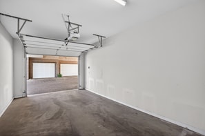 Eine Garage mit Betonboden, weißen Wänden und einer sichtbaren Garagentür.
