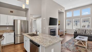 A modern kitchen with stainless steel appliances, a granite countertop, and a built-in dishwasher.