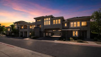 A row of modern two-story houses with large windows, a garage, and a well-maintained driveway.