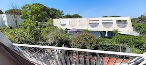 A building with a unique architectural design, surrounded by lush greenery. - Apt 2pers, air conditioning, wifi, parkg, 10mn walk to the beach (La Grande-Motte)