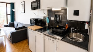 A compact kitchen with a microwave, toaster, and sink. - Apt 2pers, air conditioning, wifi, parkg, 10mn walk to the beach (La Grande-Motte)