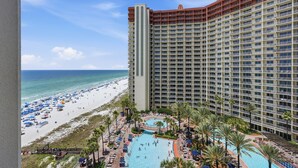 Ein Hochhaus-Hotel mit Poolanlage und Blick auf den Strand.