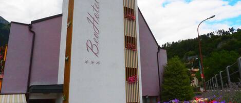 A building with a vertical sign reading 'Beef Hotel' and a flower garden in front.