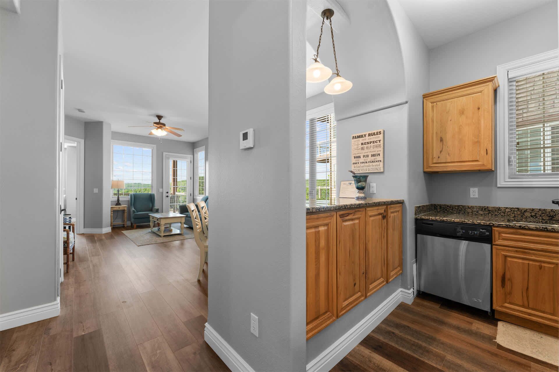A kitchen with wooden cabinets, a granite countertop, and a ceiling fan.