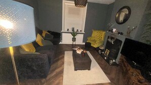 A living room with a sofa, armchair, coffee table, and a lamp. - House - Central Stamford - Sleeps 4 - Parking (Stamford)