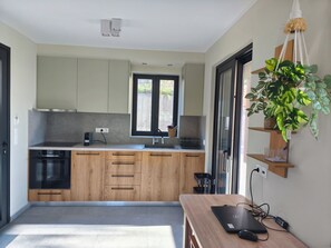 Eine moderne Küche mit Holzausstattung, einem eingebauten Backofen und einem Fenster.