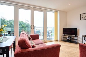 A living room with a sofa, TV, and a dining area with a table and chairs. - Host Stay 2b Hamilton Road (Felixstowe)