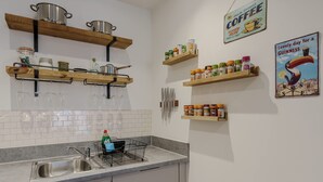 A kitchen with wooden shelves, a coffee sign, and a Guinness sign. - Host Stay Austin House (Norwich)