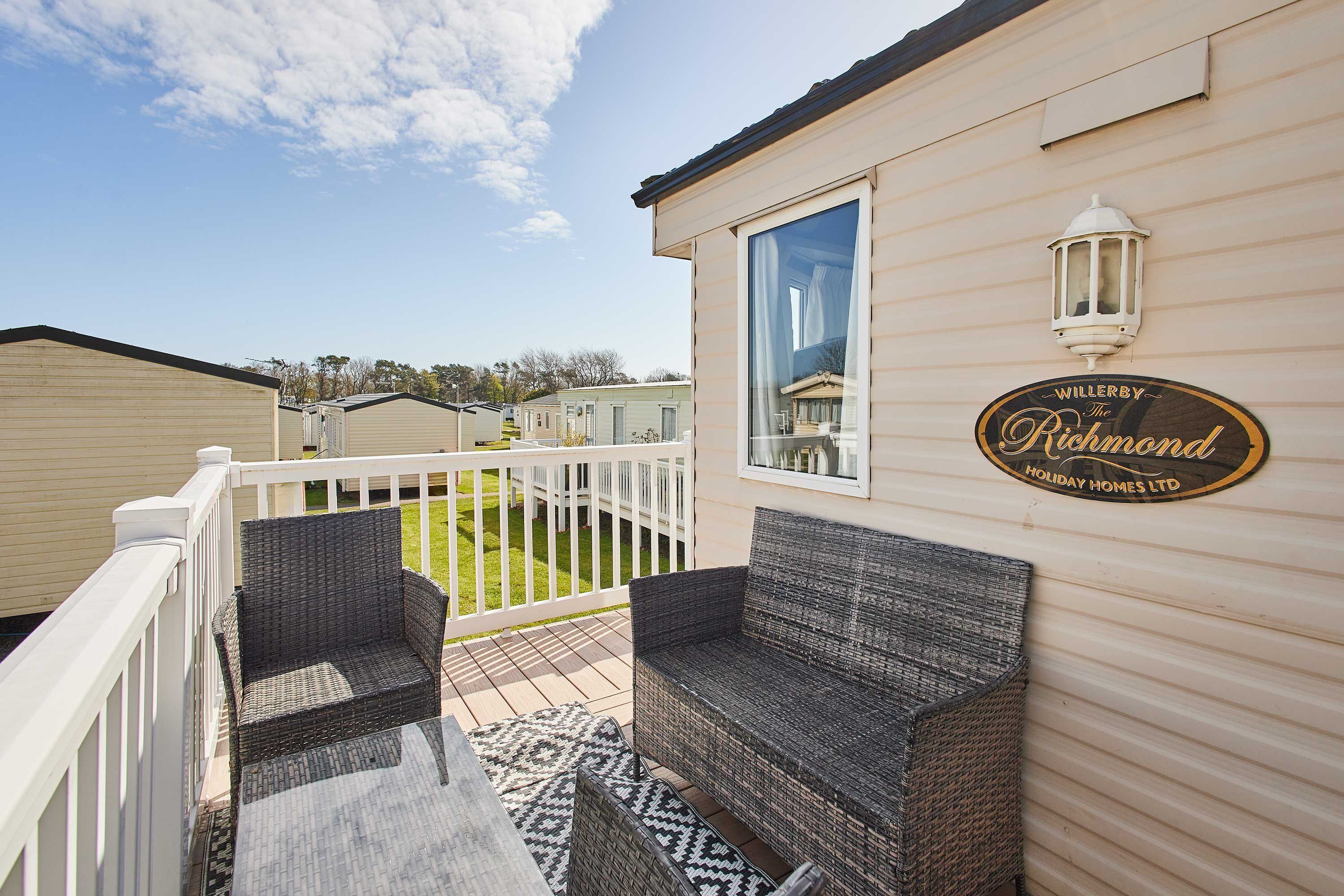 Pátio com mobiliário de vime, grade branca e placa para Willerby The Richmond Holiday Homes Ltd.