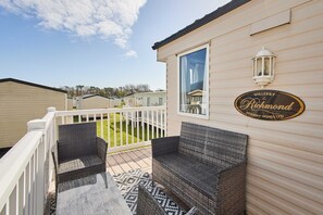 A patio with wicker furniture, a white railing, and a sign for Willerby The Richmond Holiday Homes Ltd. - Host Stay Joshua s Haven (Morpeth)