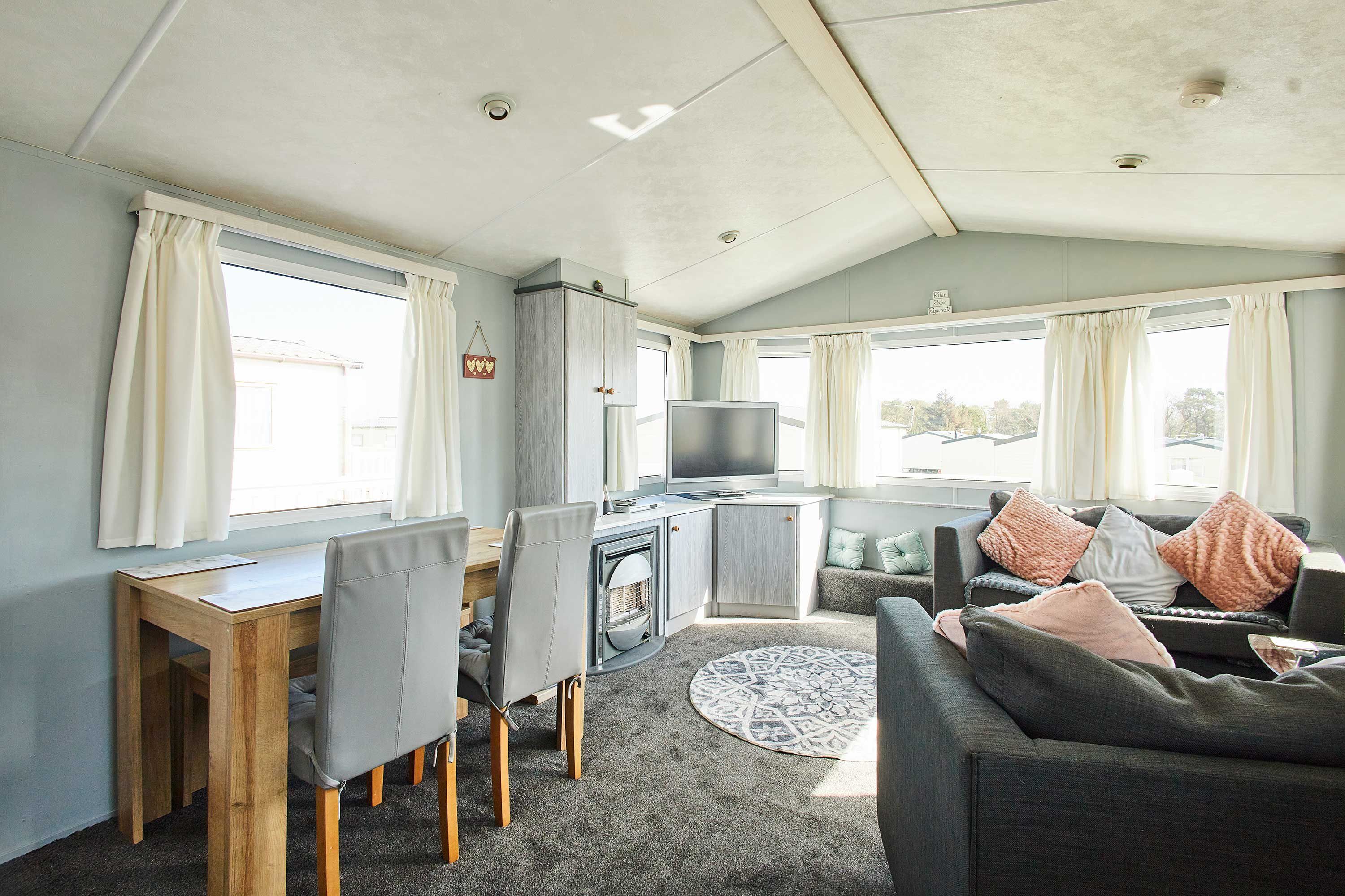 Un espacio habitable compacto con comedor, sofá y televisor.