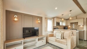 A living room with a TV, sofa, and entertainment unit. - Host Stay Stag Lodge (Pickering)