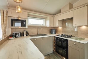 A modern kitchen with a microwave, toaster, sink, stove, and oven. - Host Stay Stag Lodge (Pickering)