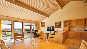 Eine geräumige Küche mit Holzausstattung und einem Essbereich mit Tisch und Stühlen.
