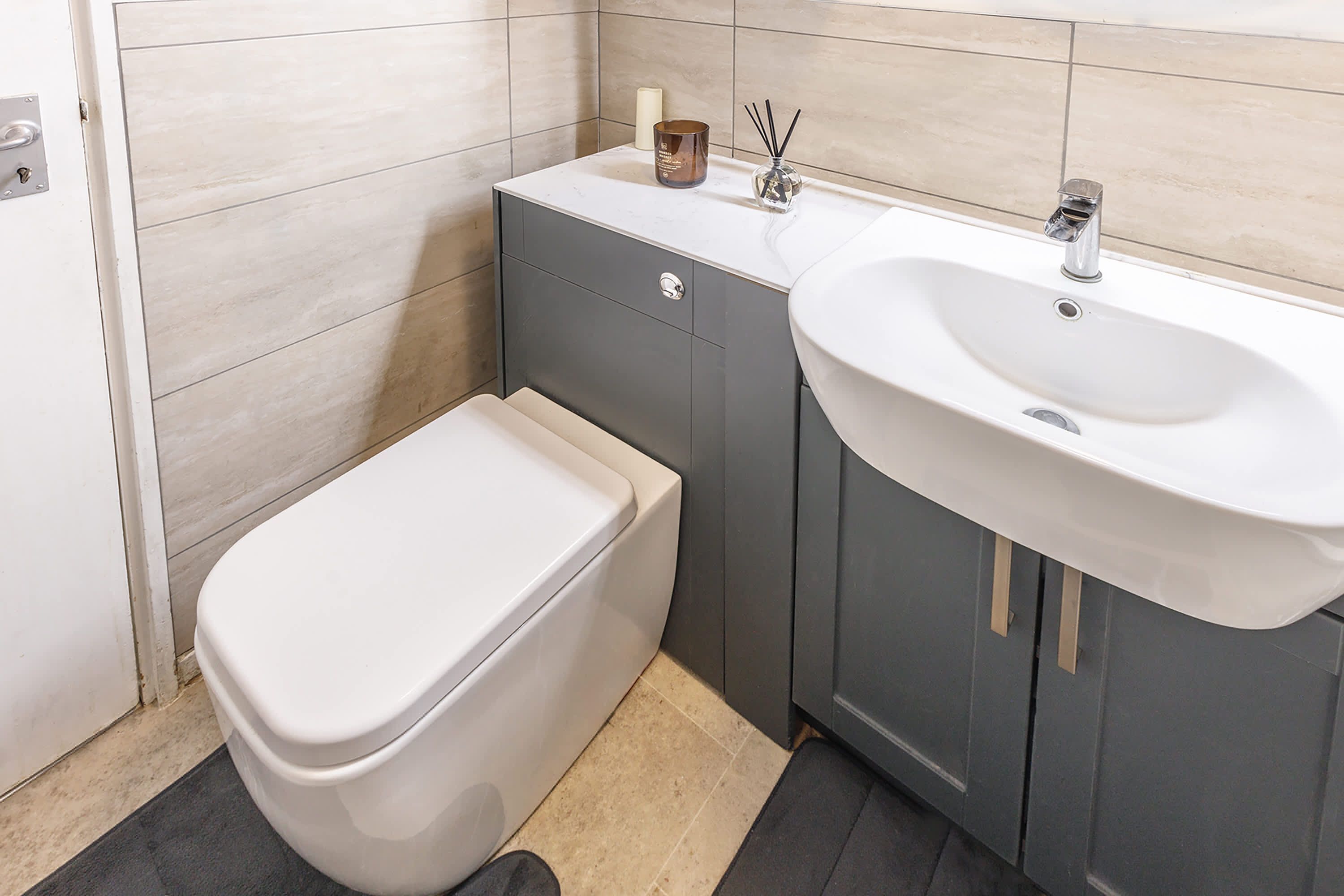 A bathroom with a toilet, a sink, and a cabinet.
