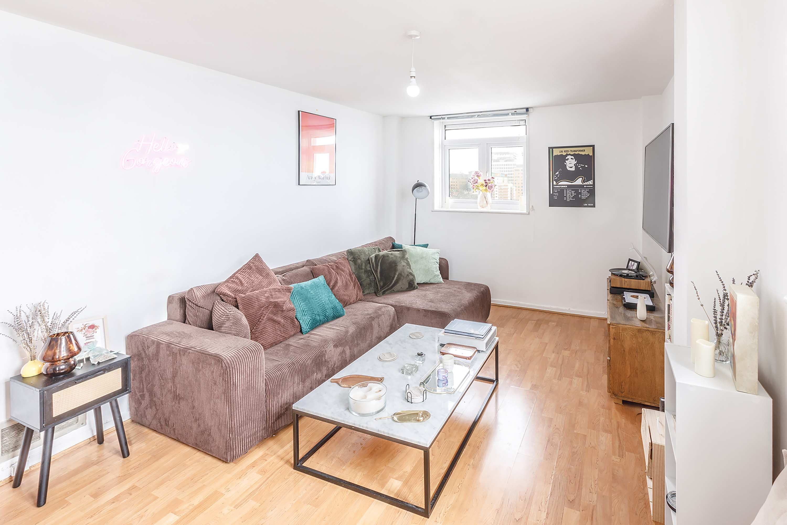 A living room with a sofa, coffee table, and a TV stand.