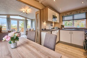 Eine Küche mit Holzausstattung, einem Esstisch mit Stühlen und einem Blumenstrauß.
