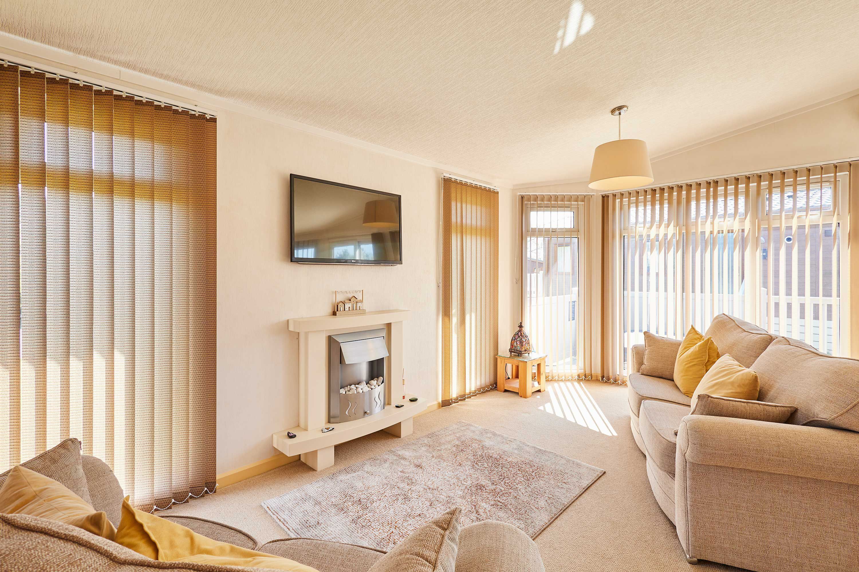 A living room with a fireplace, sofa, and TV.