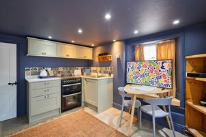Una cocina compacta con comedor, una mesa pequeña y sillas.
