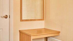 Ein Zimmer mit Holztür, einem Spiegel und einer hölzernen Bank.