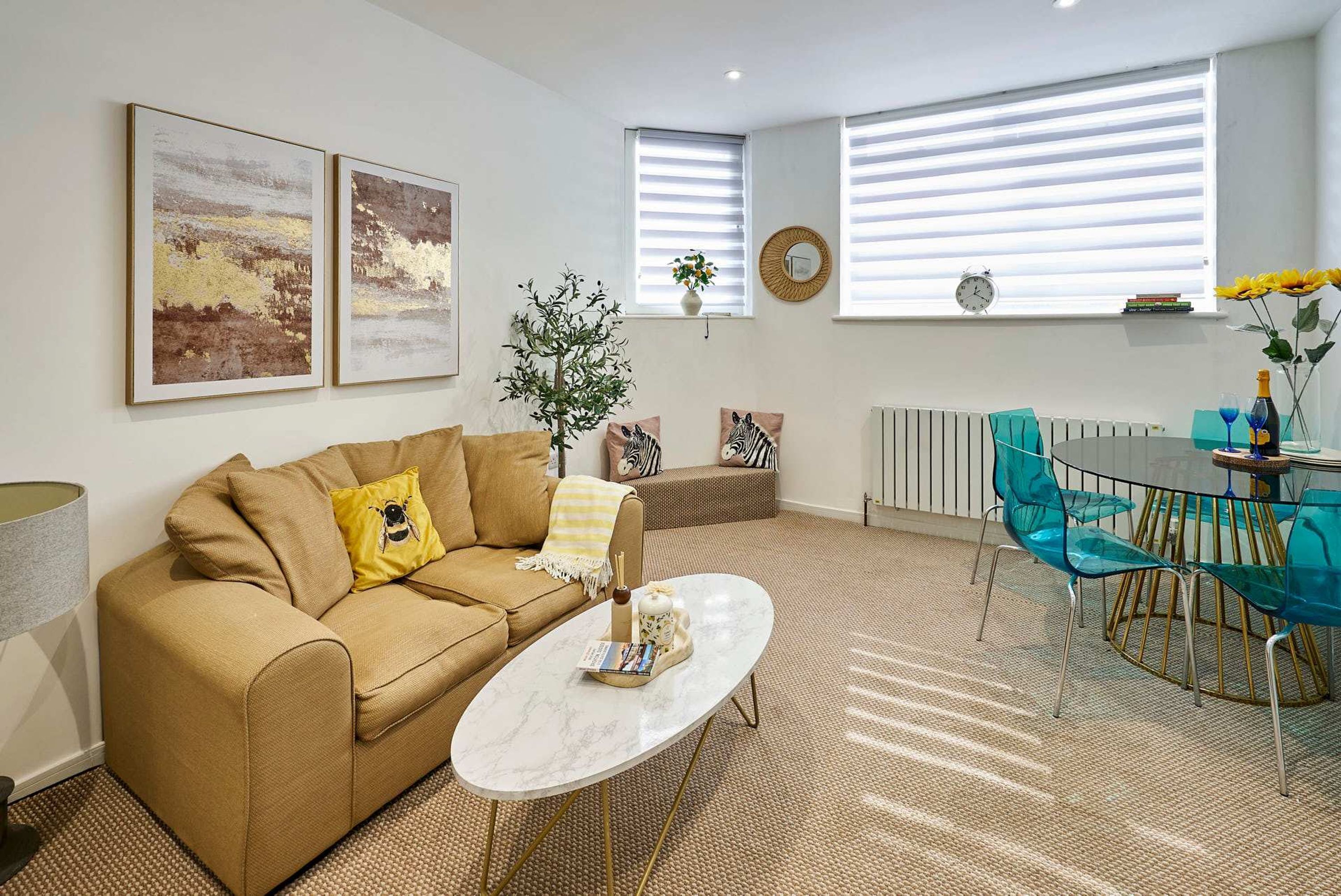 A living room with a sofa, coffee table, and a dining area with chairs.