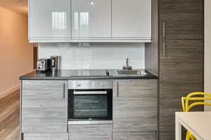 Eine moderne Küche mit grauen Schränken, einem Backofen, einer Spüle und einem Toaster.