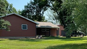 A single-story house with a red exterior, a front porch, and a garage. - Bluff’s Bend Retreat (Springfield)