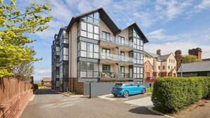 A modern two-story building with large windows, a balcony, and a parked car. - Host Stay Apartment 8 (Scarborough)