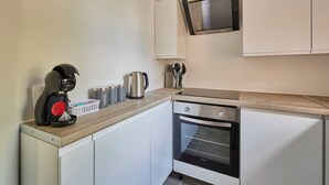 A modern kitchen with a coffee maker, kettle, and oven. - Host Stay Flat 2 Club Chambers (Malvern)