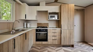 Una cocina moderna con microondas, horno y lavamanos.