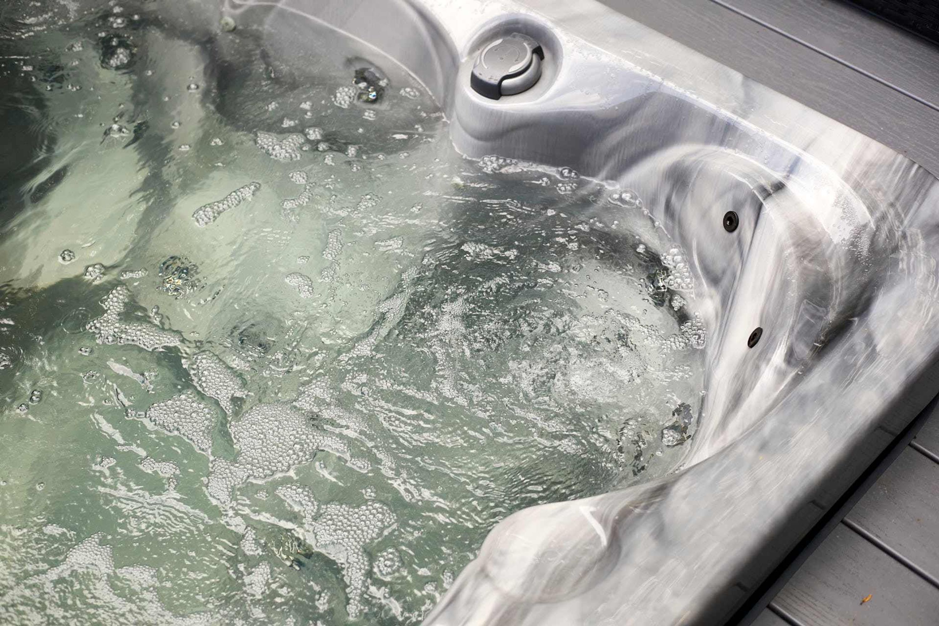 Een hottub met een metalen afwerking en een afvoer.