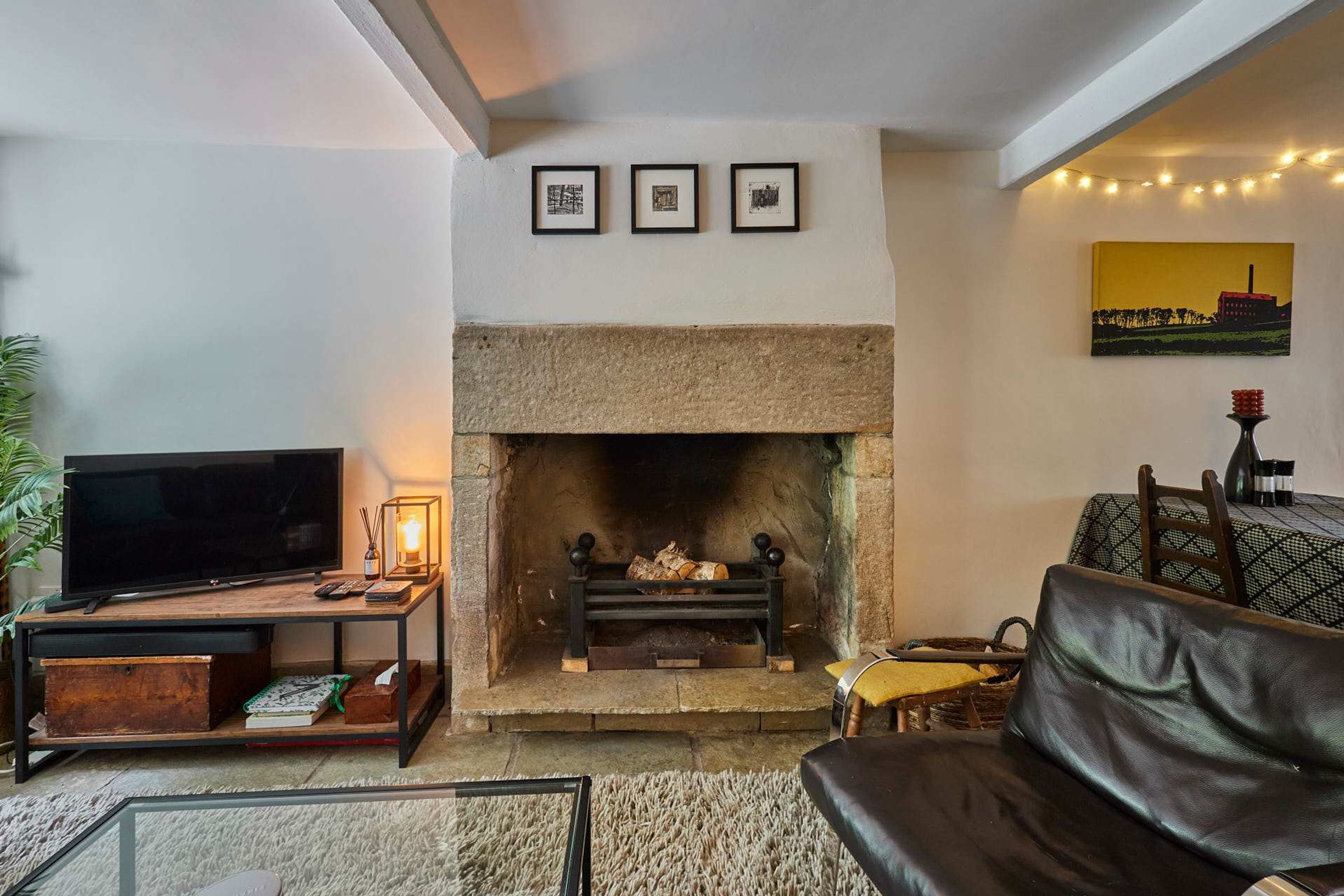 A living room with a fireplace, a television, and a sofa.