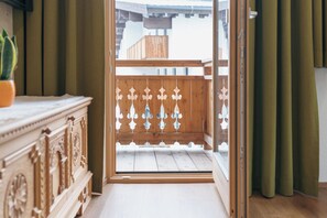 An open wooden door leading to a balcony with a wooden railing. - Apartment Kreuzspitze (Innervillgraten)