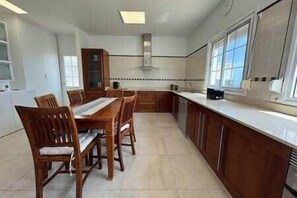 A kitchen with a dining table, chairs, cabinets, and a window. - TH - Mirador de Cristina (Breña Alta)