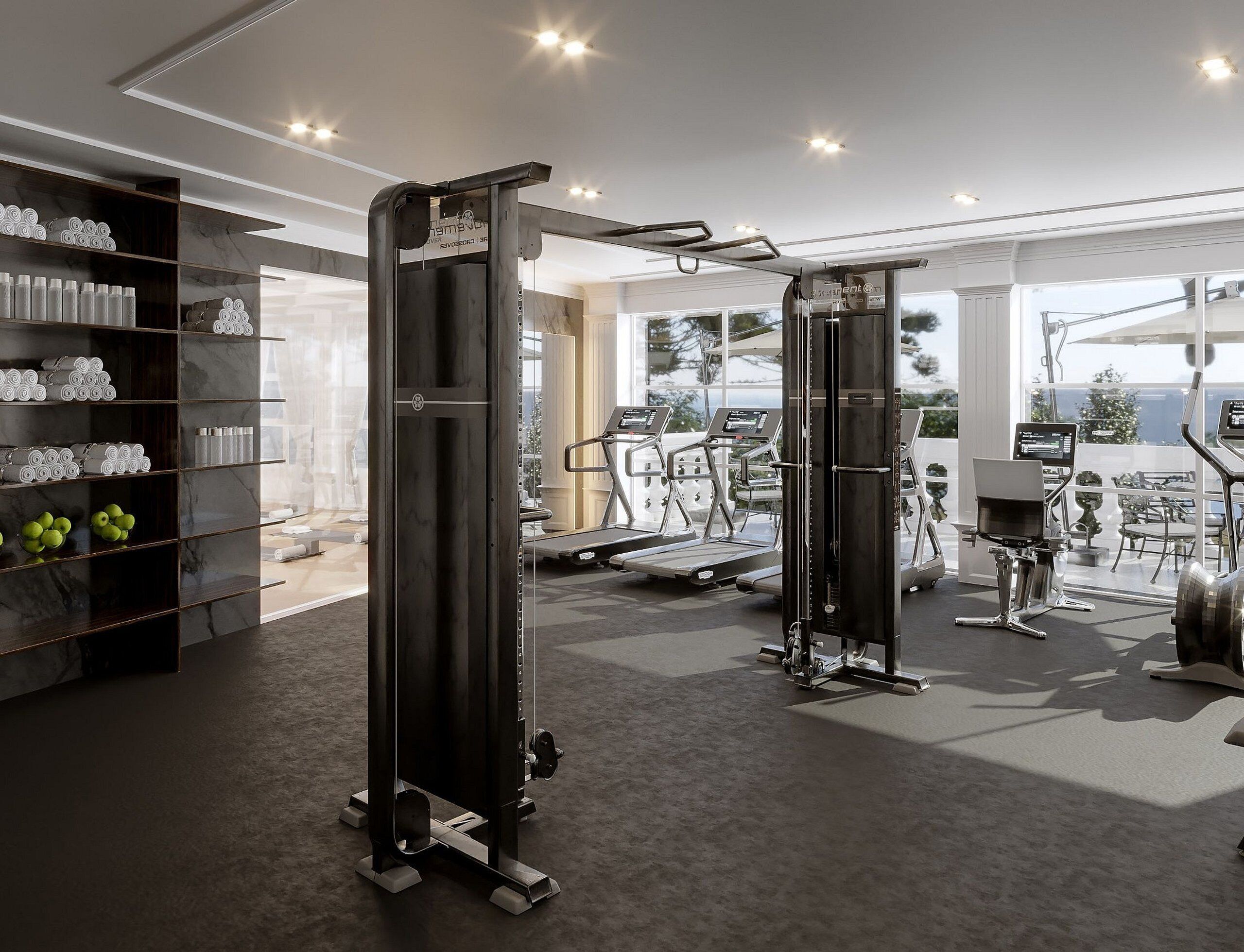 Une salle de sport équipée de matériel d’exercice, d’un tapis de course et d’un mur où sont soigneusement rangées des serviettes et des bouteilles.