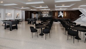 A modern indoor space with a foosball table, multiple seating areas, and a bar.