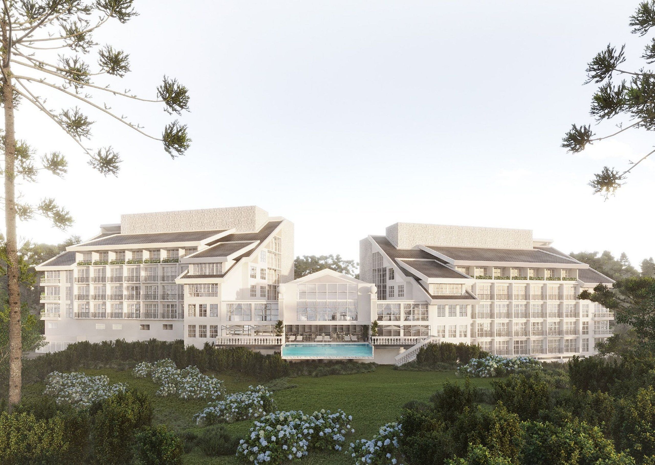A modern hotel with multiple floors, a central pool, and lush landscaping.