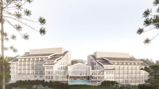 Un hotel moderno con varios pisos, una piscina central y exuberante jardinería.