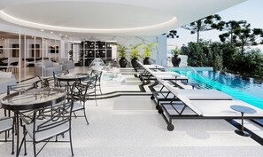 Ett modernt inomhuspoolområde med solstolar, ett bubbelbad och en sittgrupp med bord och stolar.