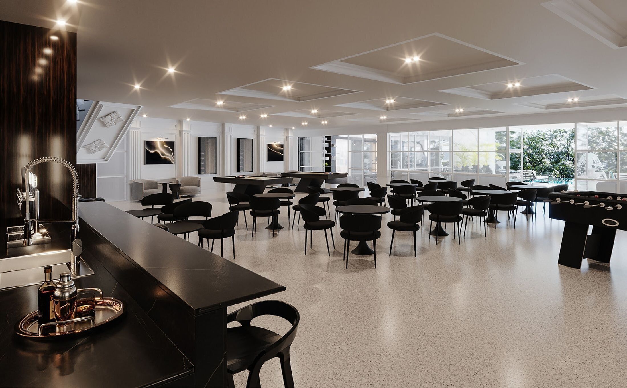Une pièce spacieuse avec un long bar, de nombreuses tables et chaises, de grandes fenêtres et un plafond doté d’un éclairage encastré.