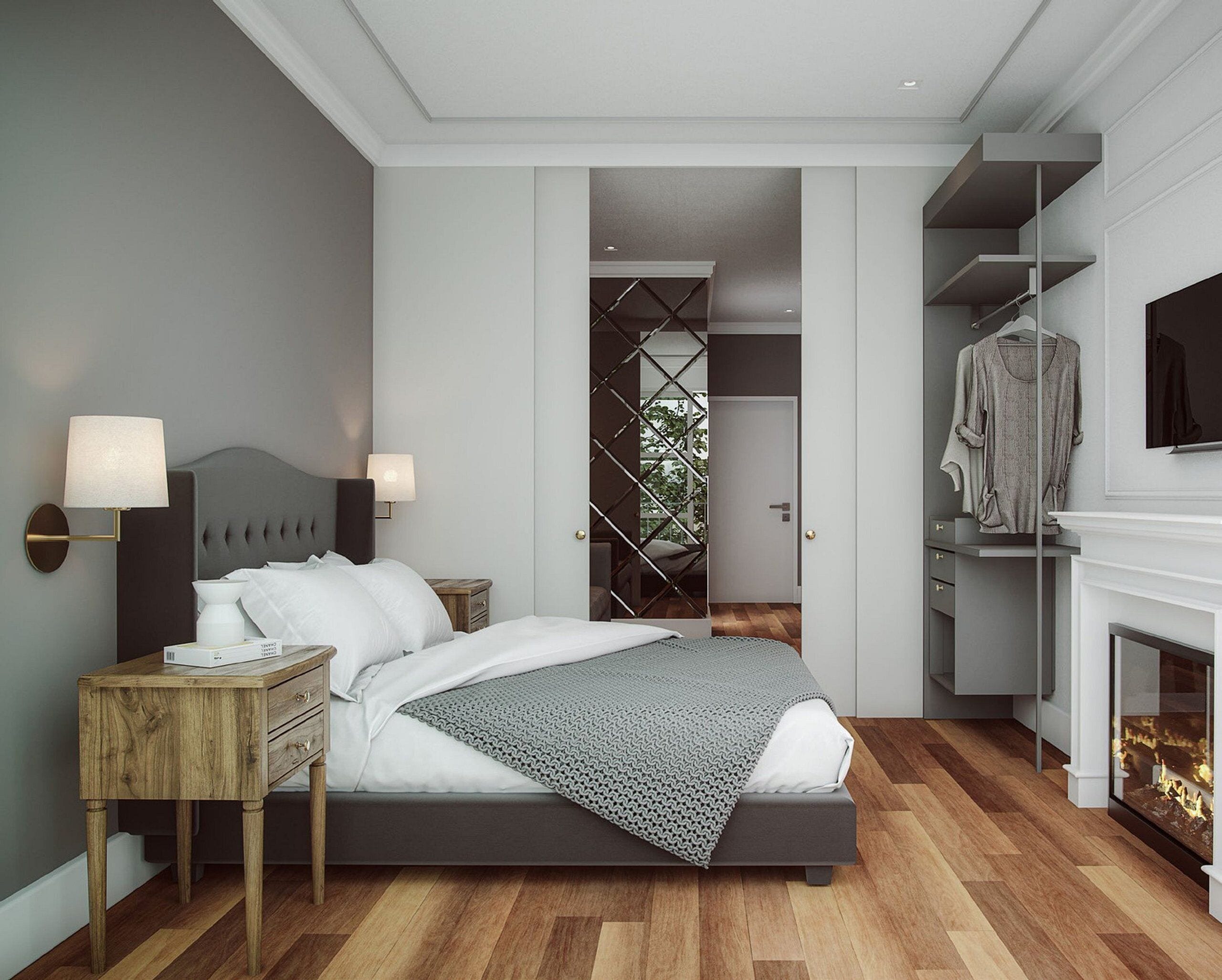 A modern bedroom with a bed, bedside lamps, a wooden nightstand, a grey headboard, a patterned throw blanket, a wardrobe, and a fireplace.