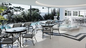 Zona d'estar exterior moderna amb piscina, seients i vista a arbres i muntanyes.