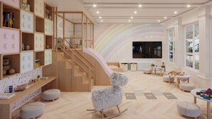 Una sala de jocs infantil amb una escala de fusta, un televisor i diversos joguets.