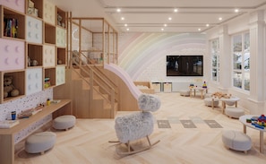 A children's playroom with a wooden staircase, a TV, and various toys. - Gran Valley Resort  - GAV Resorts (Gramado)