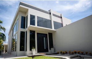 Un bâtiment moderne à deux étages, doté de grandes fenêtres et d’un toit plat.