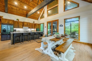 Una cocina amplia con armarios de madera, una isla central y una zona de comedor con un banco de madera.